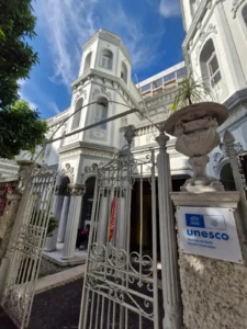 Fachada principal do casarão histórico do Colégio CAVE com a placa oficial de Membro da Rede de Escolas Associadas da UNESCO (ASPnet) em destaque